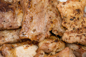 Appetizing shiny pieces of fresh roasted meat with a crusty crust lie interspersed closeup