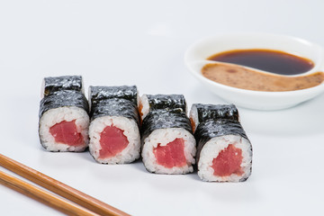Fresh delicious Japanese sushi with tuna on light background