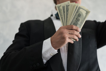 Hand of a businessman holding cash are successful in business, with many banknote dollars money. business success concept
