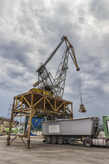 Fototapeta na wymiar Loading truck with wheat or corn from a ship with a massive crane. Uploading ship. Varna, Bulgaria