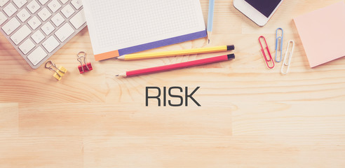 Business Workplace with  RISK Concept on Wooden Background
