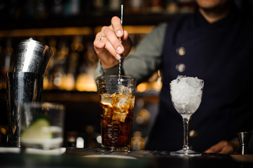 Barman making a fresh cocktail in a glass