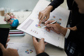 .Hand of businessman pointing to reports, graphs, business documents during the discussions at the meeting.