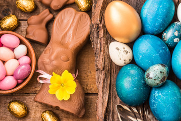 Fototapeta na wymiar Easter eggs, chocolate bunnies on wooden background, easter holiday food background.