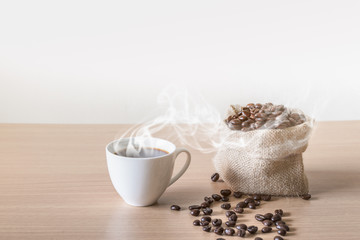 Coffee cup with coffee beans placed on a wooden table.
