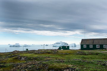 Fototapeta na wymiar Icebergs in Greenland. Village and icebergs.