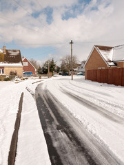 winter road through uk estate tracks no cars empty path snow