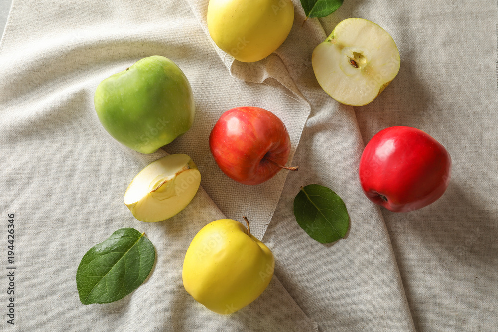 Sticker ripe juicy apples on cloth, top view