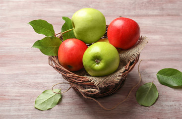 Juicy apples in wicker basket on wooden table