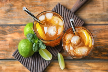 Tasty refreshing lemonade with ice in glasses on table