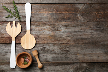 Kitchen utensils with ingredients on wooden background