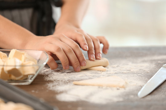 Woman preparing croissants in kitchen, closeup