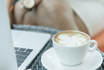 A coffee cup and white plate on the mirror table.