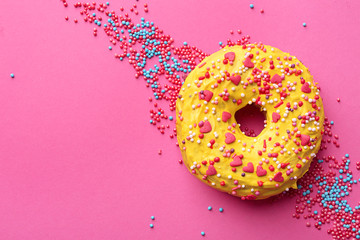 Delicious yellow donut on color background