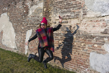 Woman who jumps on the street with smartphone in his hand