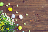Easter eggs and spring flowers on rustic wooden background