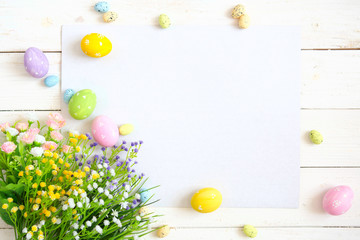 Blank sheet with easter decorations on the white wooden background. Easter greeting card