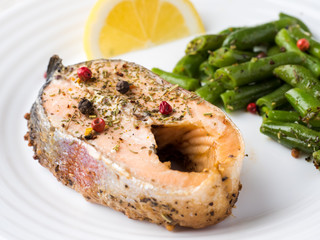 Healthy food. Baked red fish, pink salmon, salmon and green beans with a slice of lemon on a plate.