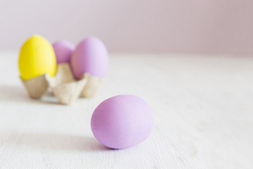 Easter postcard. Violet and yellow Easter eggs on a white vintage background. Copy space.