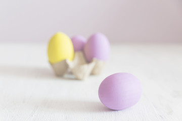 Easter postcard. Violet and yellow Easter eggs on a white vintage background. Copy space.