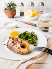 Healthy food. Baked red fish, pink salmon, salmon and green beans with a slice of lemon on a plate.