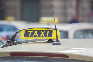 A yellow taxi sign on a taxi in the city