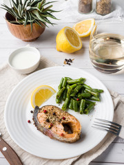 Healthy food. Baked red fish, pink salmon, salmon and green beans with a slice of lemon on a plate.