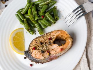Healthy food. Baked red fish, pink salmon, salmon and green beans with a slice of lemon on a plate.