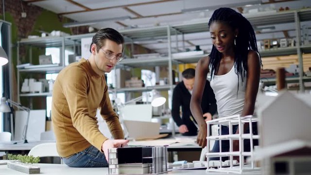 Multiracial couple working in design and engineering architecture office.