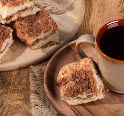 Fototapeta na wymiar Cinnamon swirl crumb cake and cup of coffee on a wooden plate