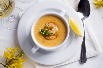 Creamy soup with seafood and lemon on a white background.