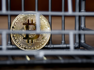 The coin is in the gray nick color put on a wooden table. The concept of investment and fluctuation of bitcoin and cryptocurrency.