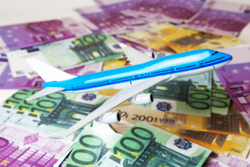 Blue white airplane on dollar and euro in cash close-up. Financial concept. tourist concept.