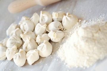 Fototapeta na wymiar Homemade dumplings and flour on the table