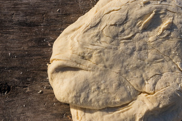 Raw fresh yeast dough for baking on rustic wooden table