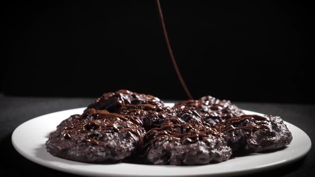 home cookies pour hot chocolate, close-up, black background, slow-motion shooting