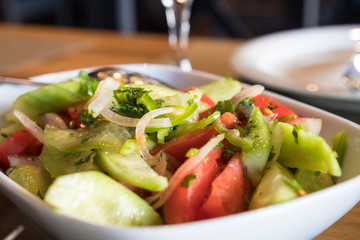 Tomato and cucumber salad with onion, pepper and parsly