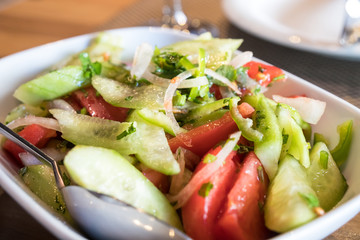 Tomato and cucumber salad with onion, pepper and parsly