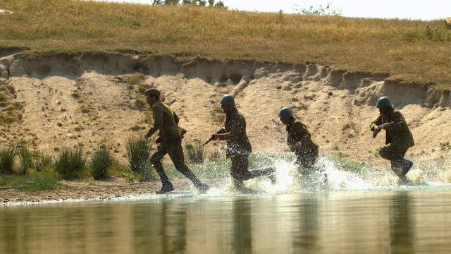 War soldiers running through the water, slow motion