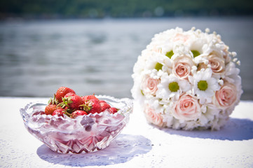 Bouquet of daisies and strawberries near the water