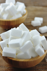 Fototapeta na wymiar Sugar cubes in a wooden bowl