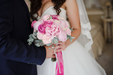 Bride and groom holding bouquet together