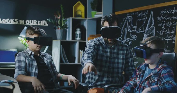 Group of kids with teacher testing VR manipulator in virtual goggles having class. Movement 4K shot on Red cinema camera.