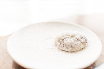 Hands shaping piece of mochi sticky glutinous rice cake dusted with starch flour to make dessert