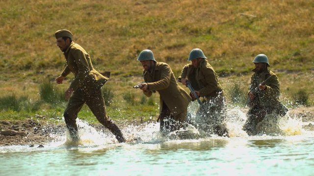 Soldiers running through the water, slow motion