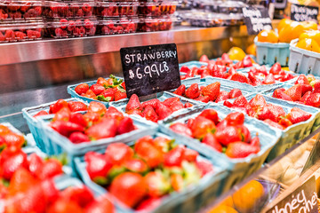 Closeup of many fresh red juicy strawberries in boxes on display expensive price per pound