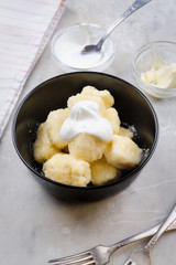 Lazy vareniki with cottage cheese (nioki) with sugar, butter and sour cream. Traditional European cuisine.
