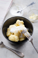 Lazy vareniki with cottage cheese (nioki) with sugar, butter and sour cream. Traditional European cuisine.