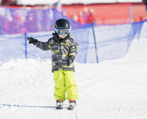 Toddler Boy Dressed Warmly & in Good Safety Gear Skiin Downhill
