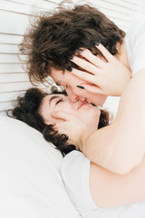 Loving couple kissing cuddling in bed